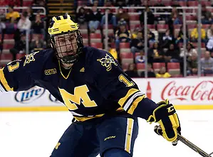 Photo By: Erica Treais Michigan forward Kevin Lynch picks at the puck in Michigan Tech's zone. (Erica Treais)