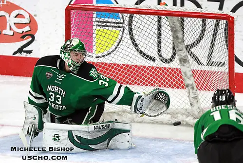 Photo By: Michelle Bishop North Dakota goalie Cam Johnson is unable to stop a shot by Omaha's David Pope during the third period. North Dakota beat Omaha 7-3 Saturday night at Baxter Arena. (Photo by Michelle Bishop) (Michelle Bishop)