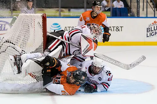 Photo By: 2017 Omar Phillips Shawn Cameron (11 - RIT) and Austin Goldstein (12 - Northeastern) collide into Cayden Primeau (31 - Northeastern) (2017 Omar Phillips)