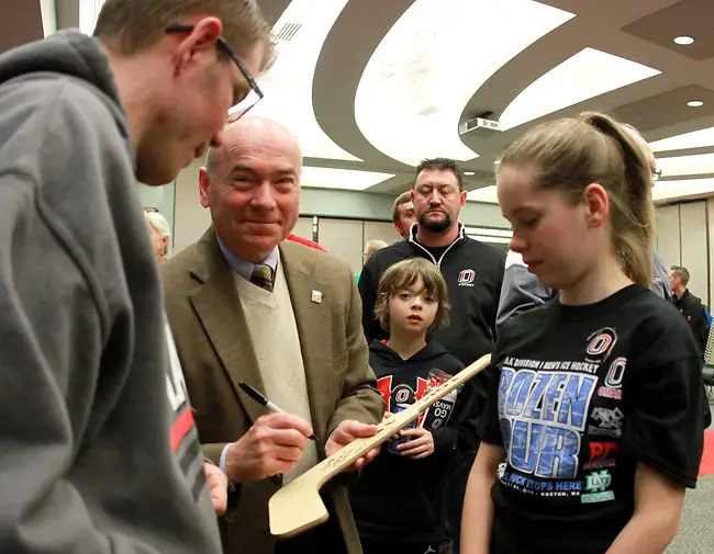 Photo By: Michelle Bishop Mike Kemp, former Omaha hockey coach and current Associate Athletic Director, signs an autograph for Michael Burns (left) during the Frozen Four send-off ceremony Monday night in Omaha. (Photo by Michelle Bishop) (Michelle Bishop)